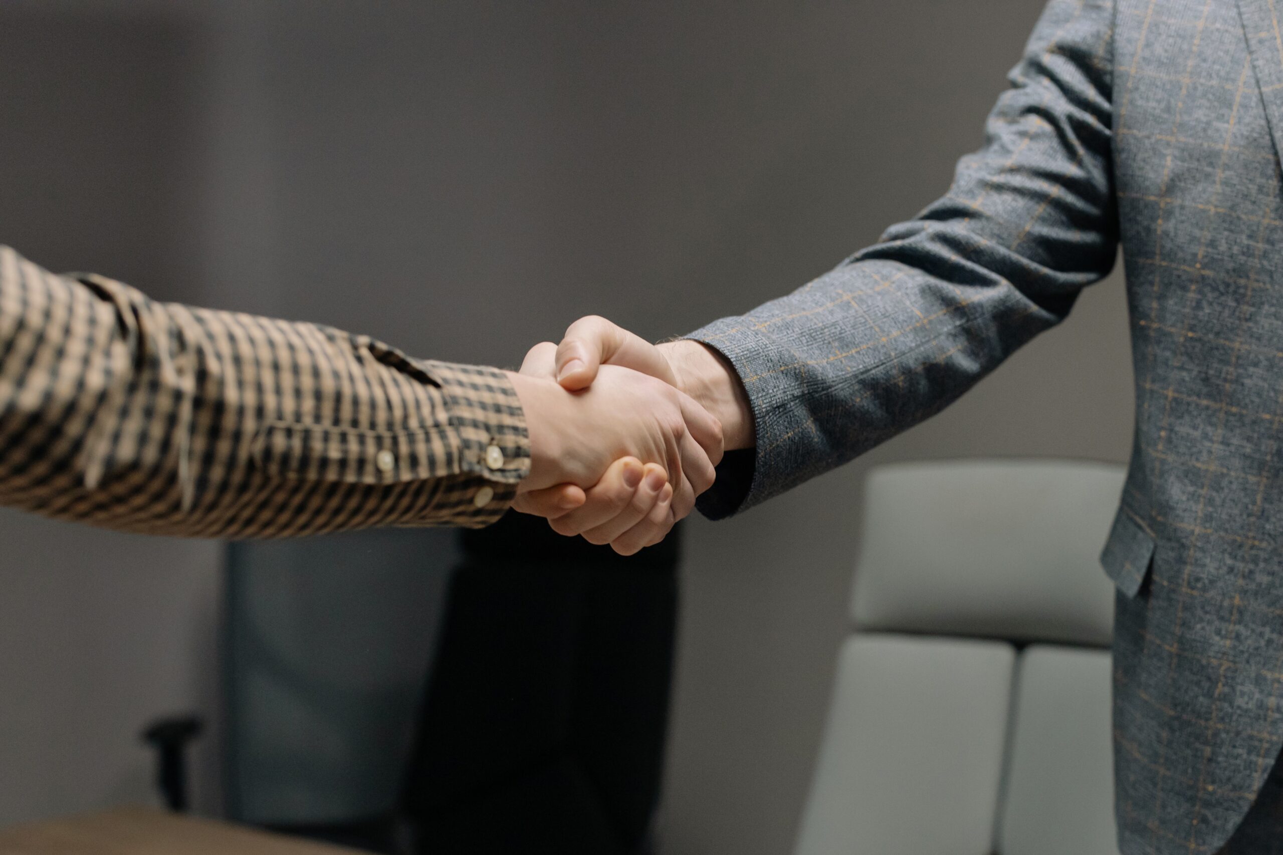Two people shaking hands in an office setting